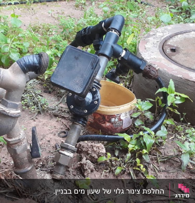 ברזים וצינורות מחוברים עם סרט שחור בגינה